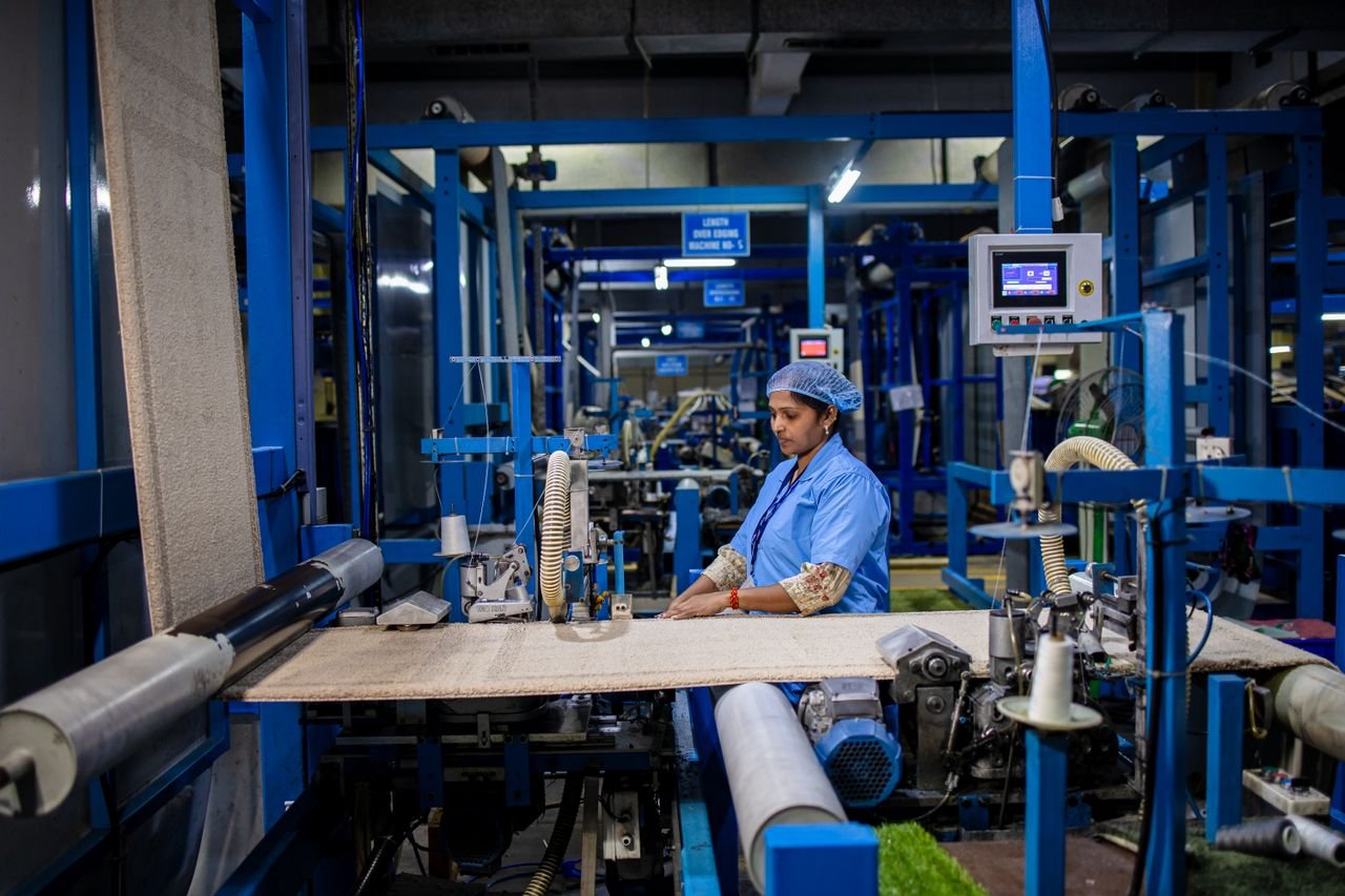 A textile factory worker operates machinery with precision, demonstrating industrial efficiency.