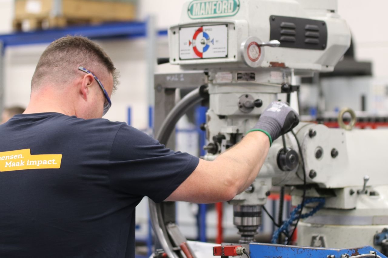The Art of Drawing Readers In: Your attractive post title goes here A worker operates a Manford milling machine in an industrial setting, showcasing precision and efficiency.